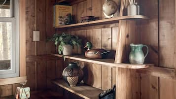 A wooden shelf with various items including a globe, a book, a plant, and decorative objects.