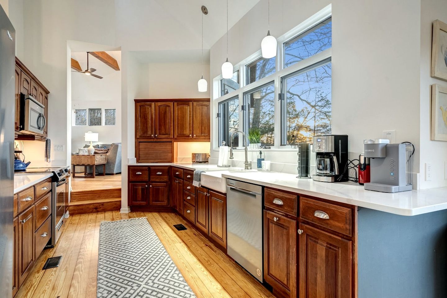 A modern kitchen with wooden cabinets, a built-in dishwasher, and a coffee maker.