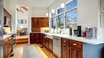 A modern kitchen with wooden cabinets, a built-in dishwasher, and a coffee maker.