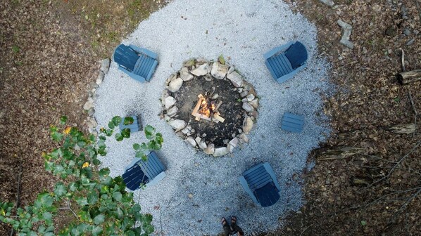 A circular fire pit surrounded by four blue benches.