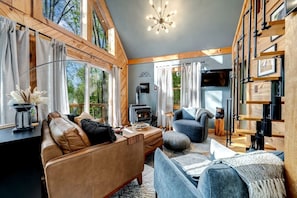 A cozy living room with a fireplace, leather sofas, and a bookshelf.