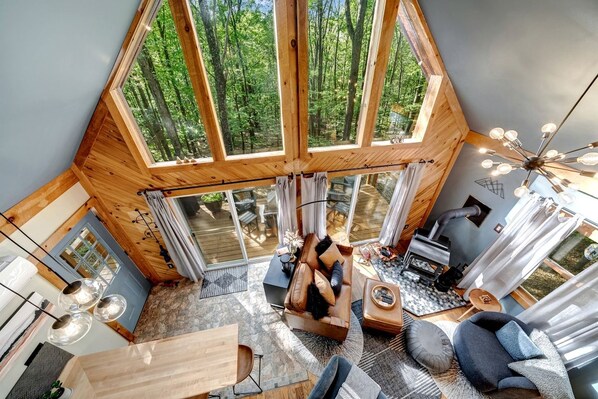 A high-ceilinged room with a large skylight, a fireplace, and a cozy seating area.