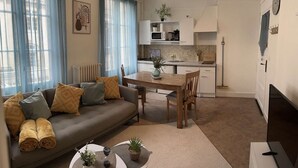 A modern living room with a sofa, coffee table, and dining area. - Bright and renovated, City center (Vitry-le-François)