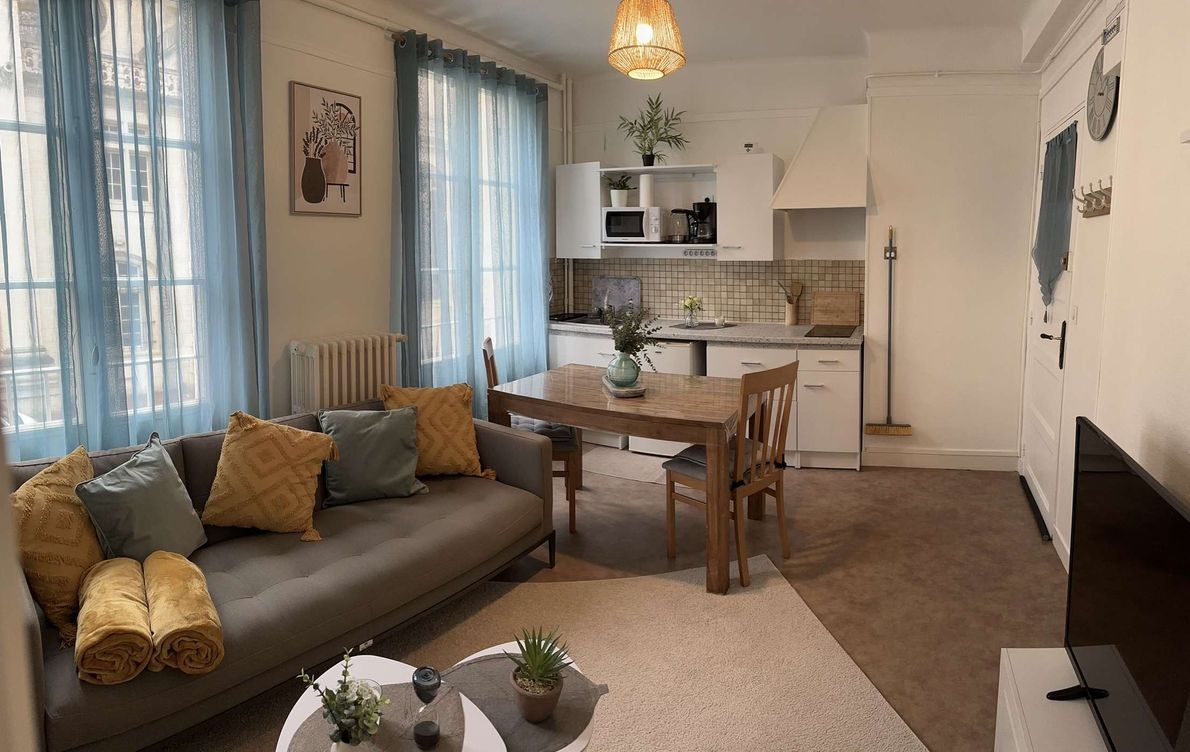 Een moderne woonkamer met een bank, salontafel en een eethoek.