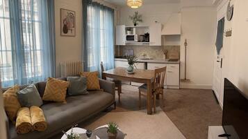 Una sala de estar moderna con sofá, mesa de centro y comedor.