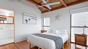 A bedroom with a bed, a ceiling fan, a star decoration, and a window with blinds. - Beachfront 3-bed With Private Pool & Fireplace (Sunshine Coast)