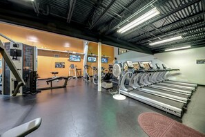 A gym with treadmills, exercise bikes, and weight machines.