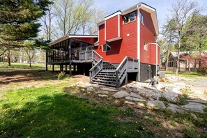 A red building with a deck and stairs leading to a second level.