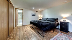 Une chambre à coucher avec un lit, des tables de chevet, un tapis et un plancher en bois.