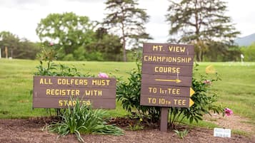 Two directional signs for a golf course, one indicating a mandatory registration with starter tees and the other pointing to the 1st and 10th tees of the Mt. View Championship Course.