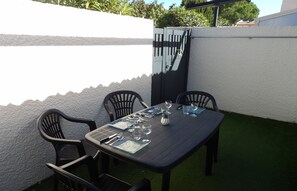 A table set for four with chairs, a small plant, and a menu. - St Cyprien charming haven near the beach (Saint-Cyprien)