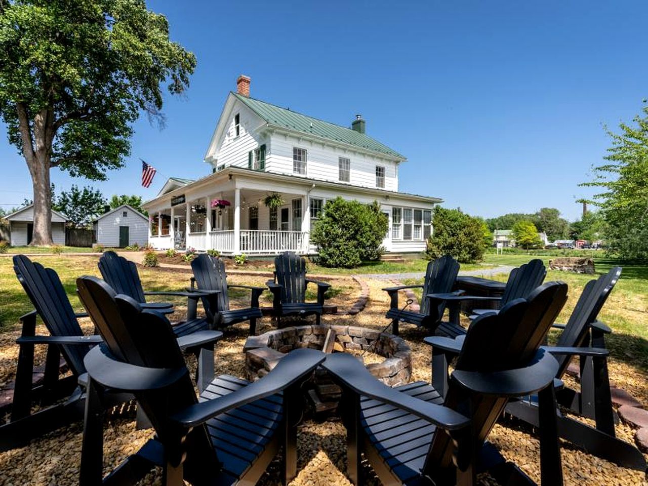 A house with a porch, outdoor seating, and a flag.