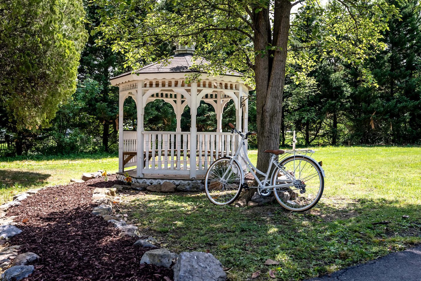 Una pérgola con una bicicleta estacionada adelante.