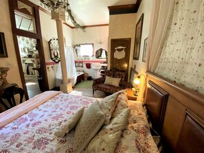 Une chambre à coucher avec un lit, une chaise, une table de chevet et une fenêtre.
