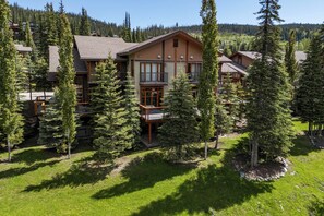 Eine Lodge mit mehreren Etagen, großen Fenstern und einem Balkon.