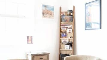 A room with two chairs, a bookshelf, a small table, and a rug.