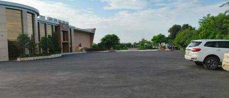 A parking lot with a building labeled "Riviera D'Azur" and a white SUV parked on the right.