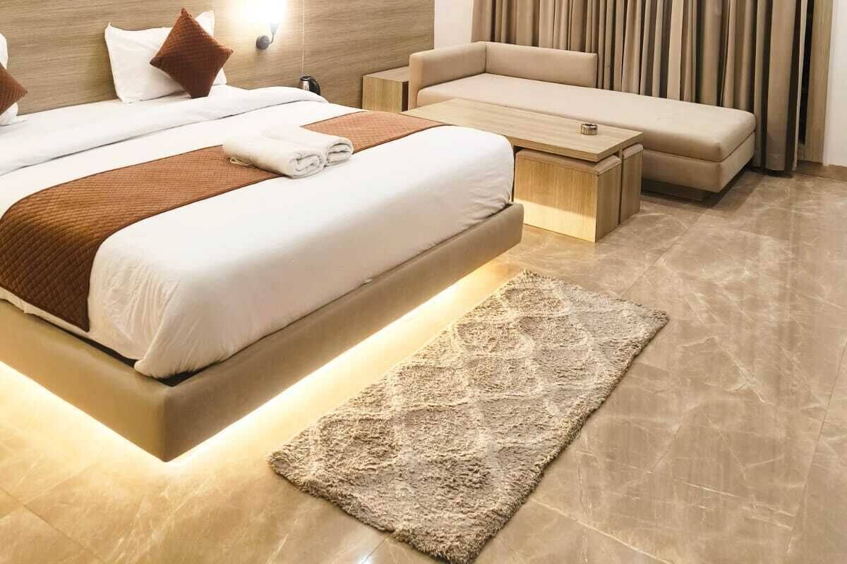 Ein modernes Hotelzimmer mit einem großen Bett, einer Couch, einem Couchtisch und einem Deckenventilator.