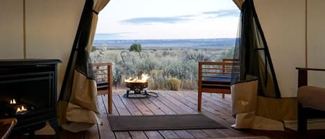 Un cuarto acogedor con chimenea, un pequeño brasero y vistas del paisaje.