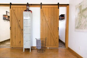 A room with a sliding barn door, a metal filing cabinet, a metal rack, and a map on the wall.