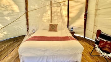 A bed with a canopy in a tent-like room.