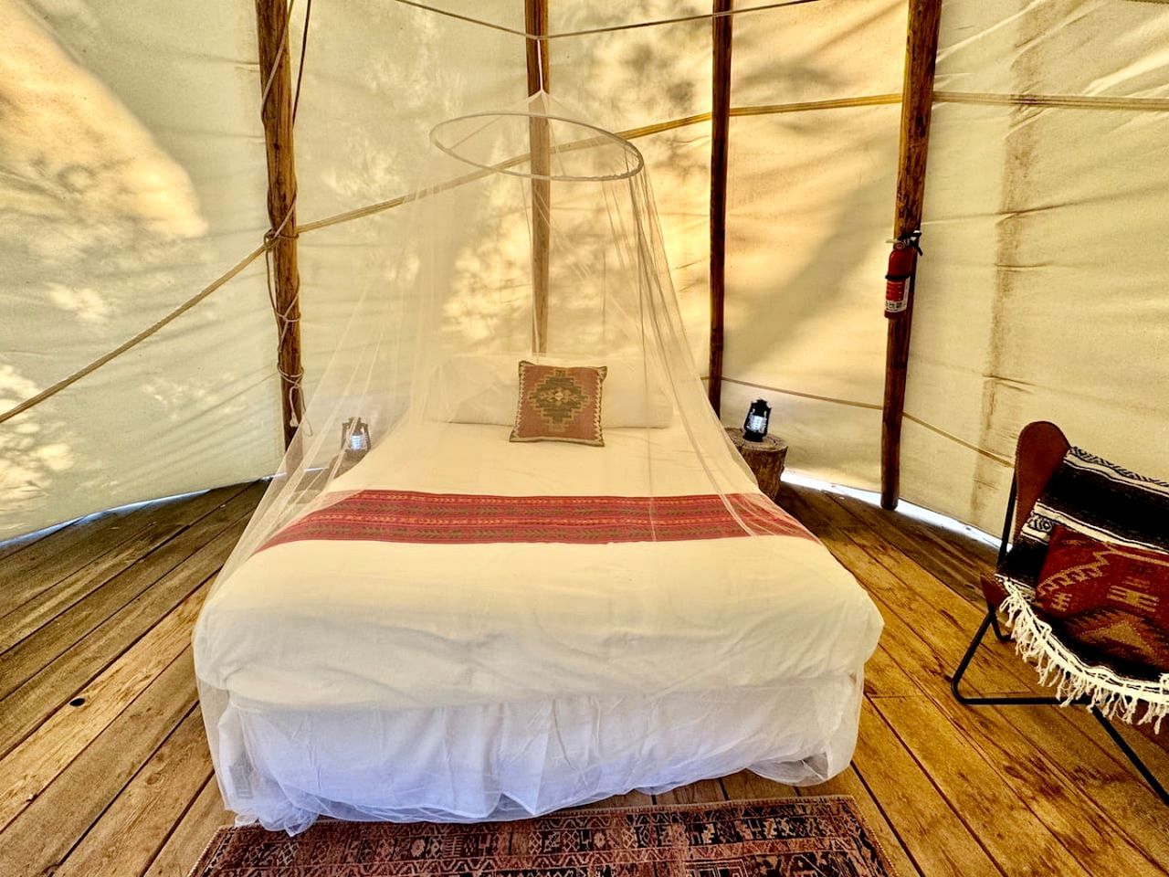 A bed with a canopy in a tent-like room.