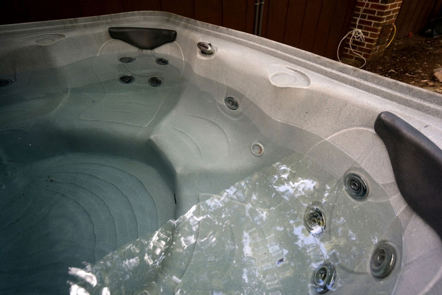Un jacuzzi con múltiples chorros, un asiento integrado y un desagüe.