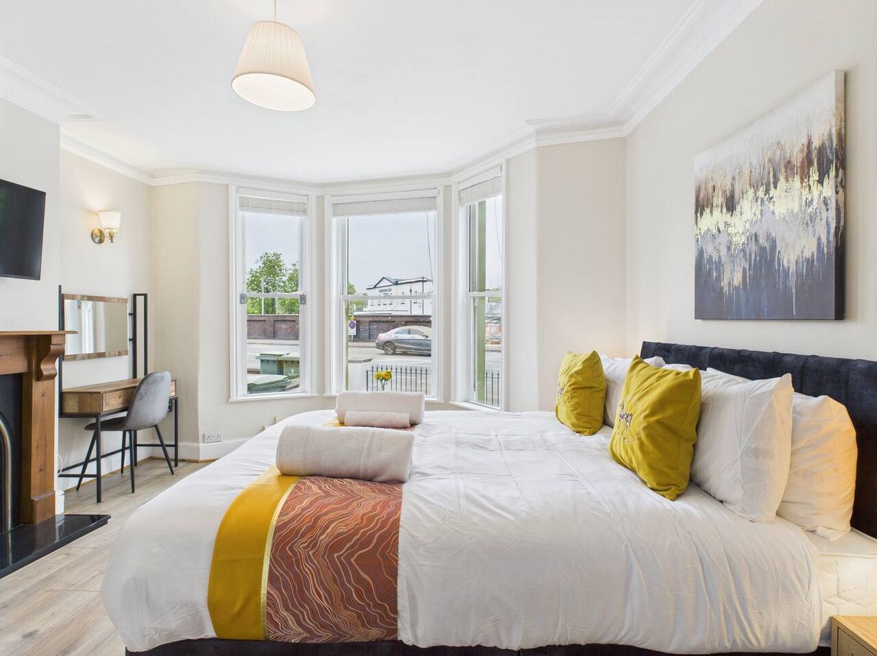 Un dormitorio moderno con una cama grande, un escritorio y vistas al exterior.
