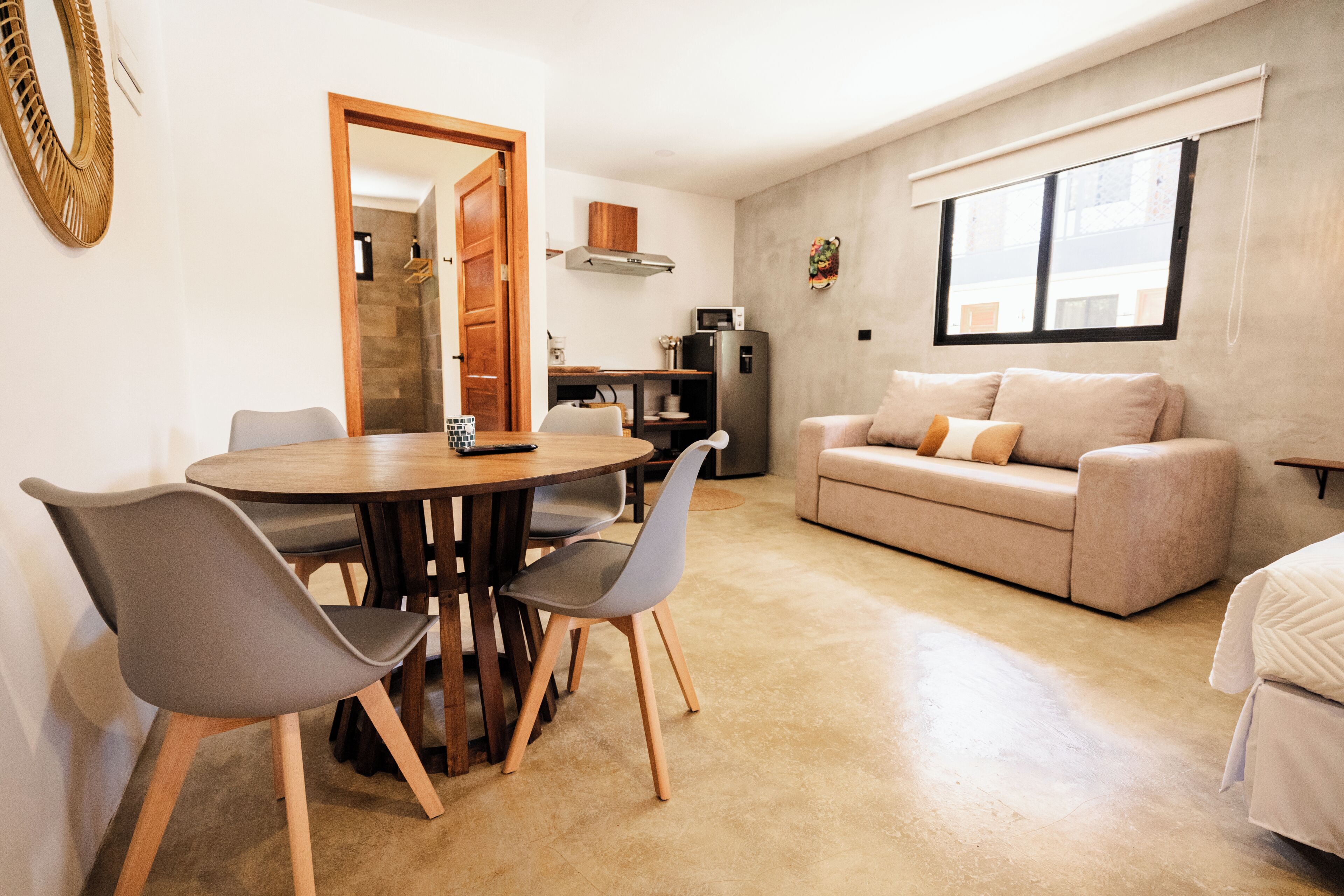 Un espacio habitable compacto con comedor, kitchenette y sofá.