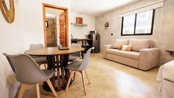 Un espacio habitable compacto con comedor, kitchenette y sofá.