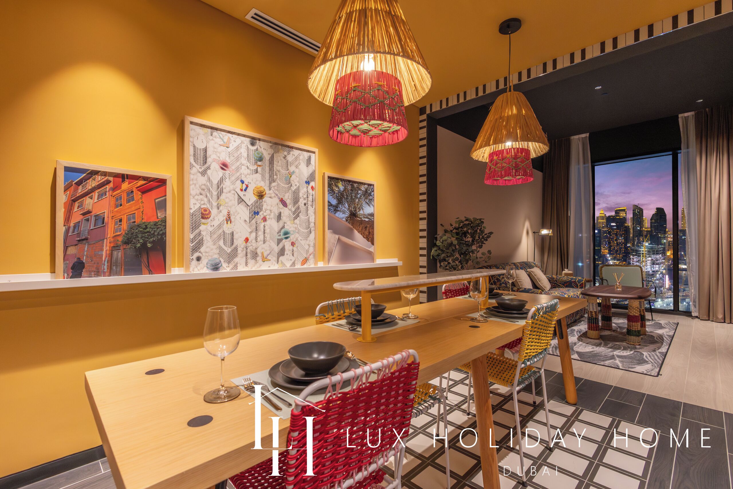 A modern dining area with a long table, red woven chairs, and pendant lights.
