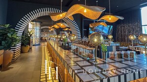 Un espace bar moderne, doté d’un éclairage original, d’un sol à carreaux et d’un grand écran diffusant une vue panoramique sur la ville.