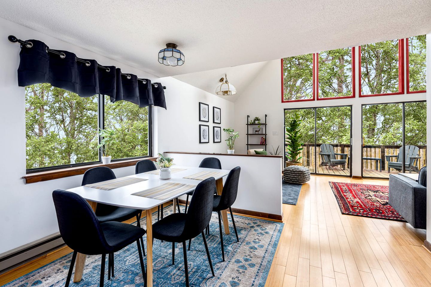 A modern dining area with a table, chairs, and a view of the outdoors.