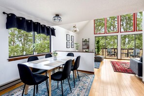 A modern dining area with a table, chairs, and a view of the outdoors.