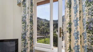 A room with a window overlooking a green landscape and hills. - Charming Balcony Apartment by Wonderful Italy (Santa Margherita Ligure)
