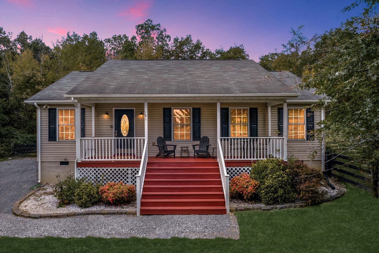 A two-story house with a front porch, a red staircase, and a mailbox.
