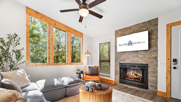 A modern living room with a fireplace, large windows, and a mounted sign.