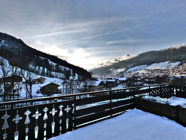 Ein verschneites Dorf mit Häusern und einer Holzbrücke.