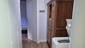 A narrow hallway with a wooden wardrobe and a washing machine. - 68 sqm 3-Bedroom Apartment with Terrace and Ski Locker (Cauterets)