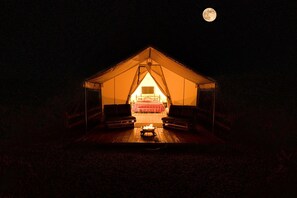 Una carpa con una cama, una mesa y un brasero.