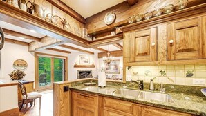 Eine Küche mit Holzschränken, einer Granit Arbeitsplatte und einem Spülbecken.