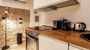 A modern kitchen with a stone wall, built-in oven, and stainless steel appliances. - Antrum Loft, eaperience with Jacuzzi (Salerno)