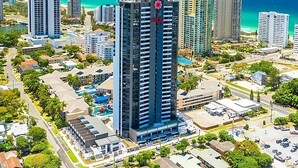A high-rise building with a modern design, surrounded by other high-rise buildings and a coastal view. - 2-bed Beach Apartment With Pool, Parking & Balcony (Gold Coast)