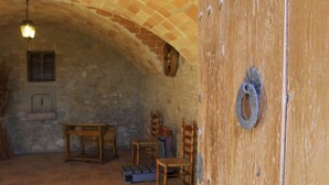 A rustic room with a wooden door, a small table, and chairs. - Casa Serra de Dalt (Lladurs)