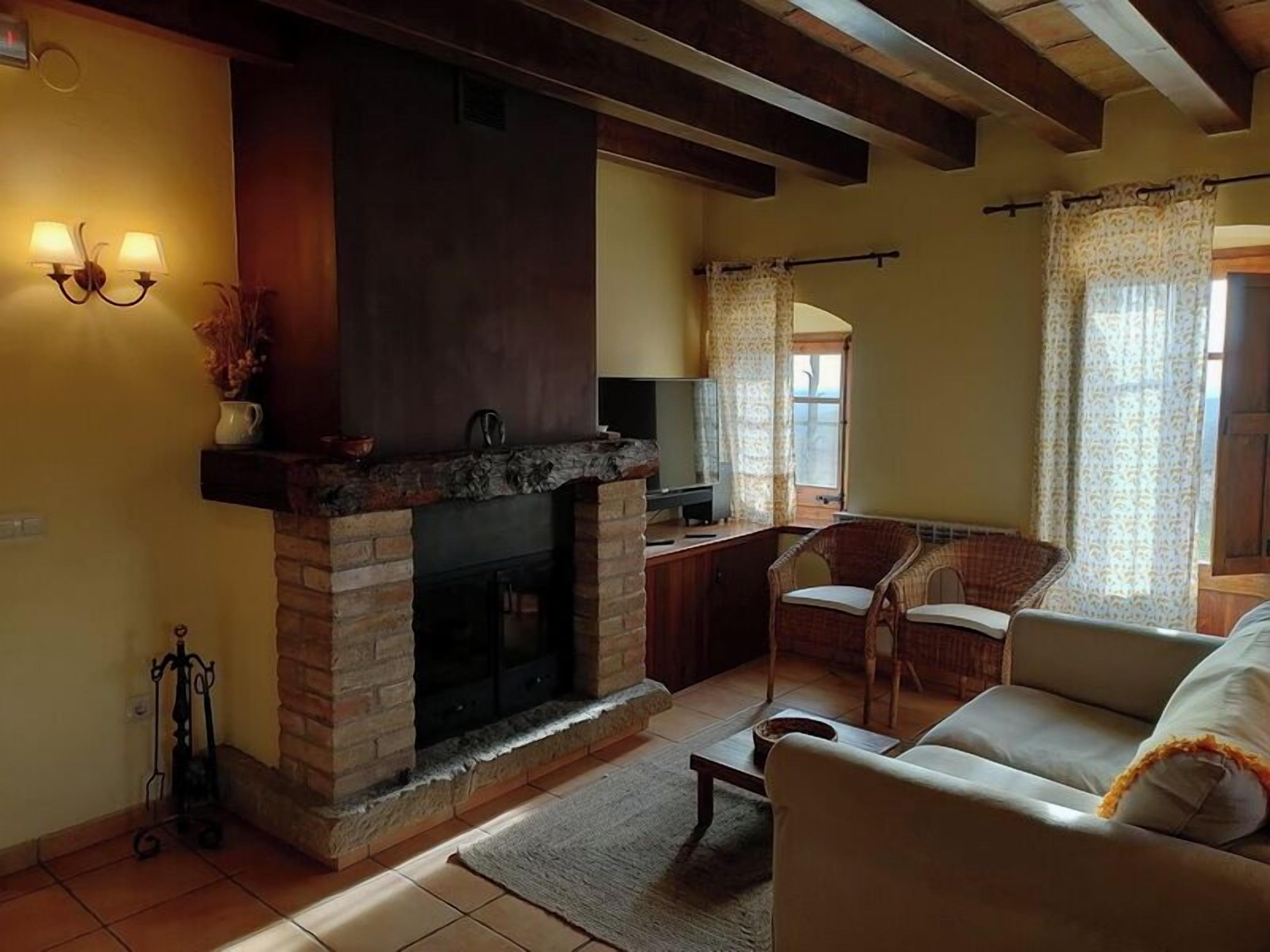 A cozy living room with a fireplace, a sofa, and a television.