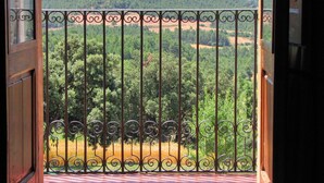 A balcony with a wrought iron railing overlooking a forested valley. - Casa Serra de Dalt (Lladurs)