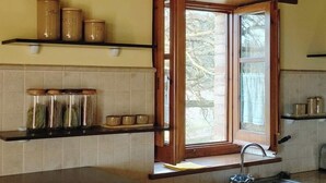 A kitchen with a window, a sink, and shelves with jars. - Casa Serra de Dalt (Lladurs)