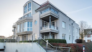 A modern multi-story building with balconies, a staircase, and a gated entrance. - Holiday Apartment 'Sonnendüne Im Dünenblick' with Sea View, Balcony & Wi-Fi (Ostseebad Boltenhagen)