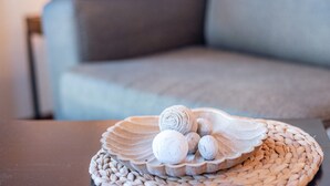 A woven tray with rolled items on a table, a sofa in the background. - Holiday Apartment 'Sonnendüne Im Dünenblick' with Sea View, Balcony & Wi-Fi (Ostseebad Boltenhagen)