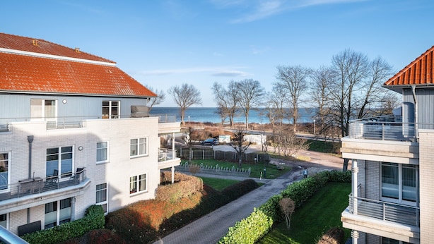 A residential building with a red-tiled roof, multiple balconies, and a view of the sea. - Holiday Apartment 'Sonnendüne Im Dünenblick' with Sea View, Balcony & Wi-Fi (Ostseebad Boltenhagen)